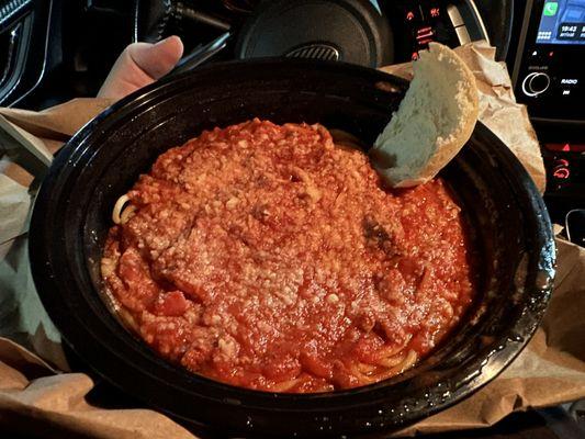 Spaghetti with meat sauce and roll.