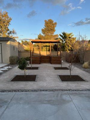 Young fruit trees and covered raised garden.