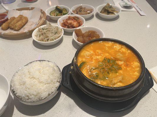 Mandu soondubu (Dumpling spicy soft tofu soup), banchan (side dish; fish cake, kimchi, potato, fried onion pancake, pickled cucumber)