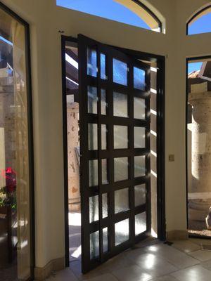 Custom Iron PIVOT Door With Decorative Rain Glass and Full length Custom Door pull  built into the design.