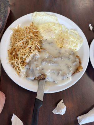 Country fried steak with over easy eggs and hash browns