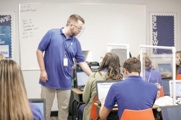 2020 High School students receiving help with a question.