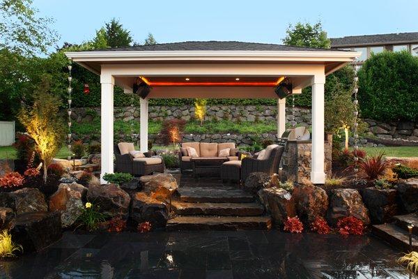 Outdoor covered patio with kitchen and natural boulders to accent the landscape.