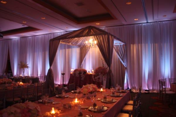 Sweetheart Fabric Tent design with light lavender lighting and pink pintuck taffeta tablecloths. ballroom full pipe and drape