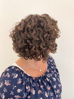 An after picture of a guest. Short curly hair.