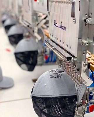 Custom hats being embroidered with high-quality precision on our assembly line.