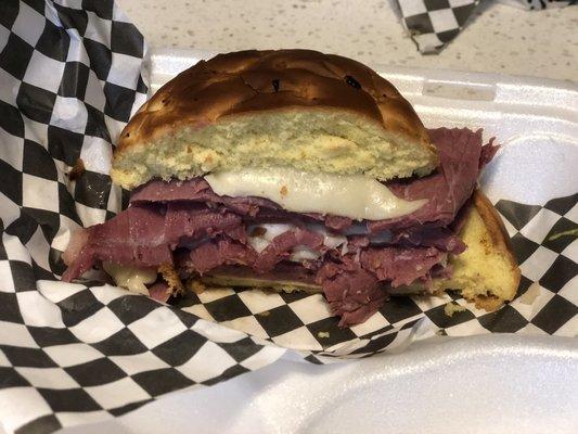 Corned beef sandwich! Very thick sliced, juicy and flavorful meat with Swiss cheese and mustard on a French onion bun.