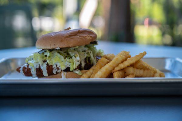 Hot Chicken Sandwich topped with house ranch and buffalo sauce and served with a side of fries