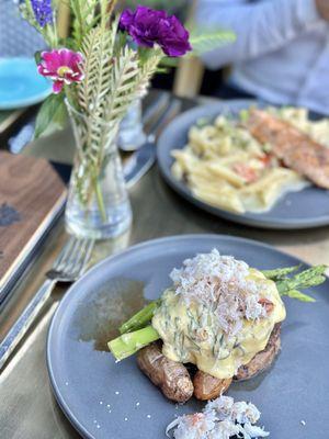 Filet mignon topped with crab and asparagus in the front and salmon penne in the back.