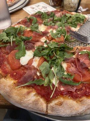 Prosciutto cheese and arugula pizza