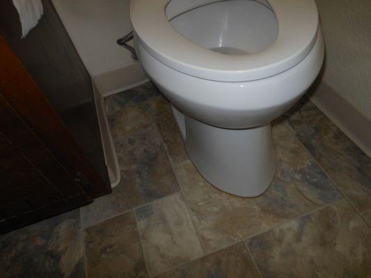 New toilet and flooring. Caulking was scrubbed and bleached, before this picture was taken and still looks bad.