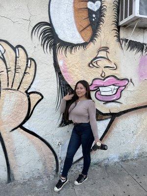 Sand Oner next to her mural