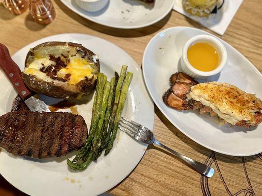 Steak, asparagus, baked potato, and lobster tail