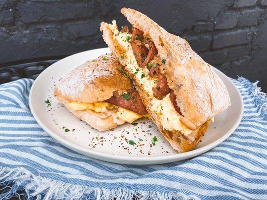 scrambled eggs,  andouille sausage, remoulade, aged cheddar, ciabatta