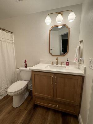 Bathroom vanity with under-mount sink and splash guard.