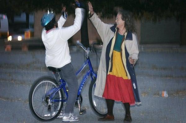 Susan shares a high five with a student who just got her balance