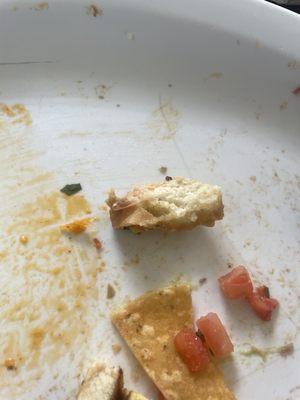 Found this in the nacho.. (looks like a piece of bread from a previously consumed dish) this indicates certain practices