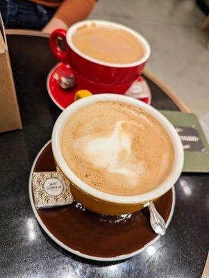 Latte. $6.75. Hot, English Toffee ($0.75), Oat Milk ($0.75). In the back is a Mocha. $5.75. Hot, Oat Milk ($0.75).