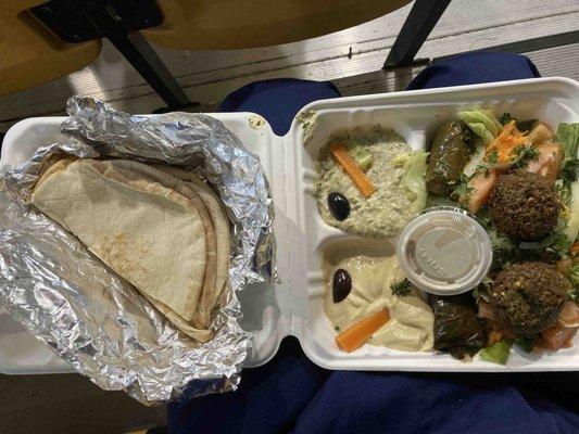 Combination platter - hummus, baba ghanouj, felafel, grape leaves, salad and warm pita bread.