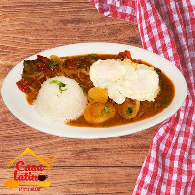 Bistec a Caballo: Skirt steak slowly cooked in a tomato and onion sauce, topped with two fried eggs. Served with rice, cornmeal flatbread an