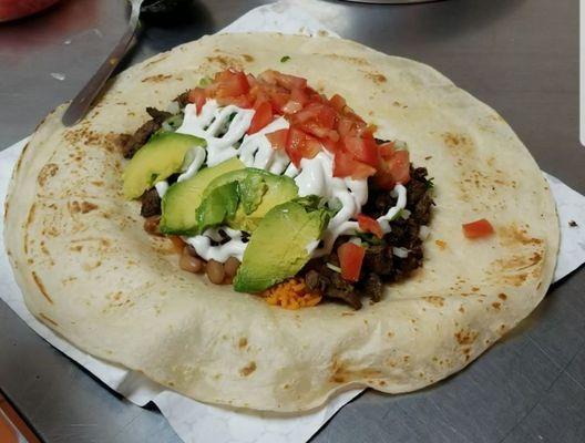 Steak burrito with everything plus sour cream, tomatoes, and avocado