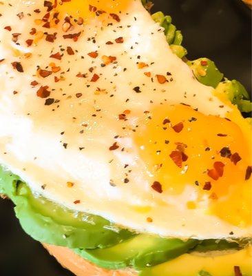 Avocado toast with eggs and chili peppers.