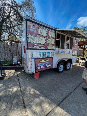 Little food truck in a gas station parking lot