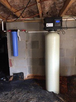 A professionally installed filox filter for iron removal in a residential crawl space.