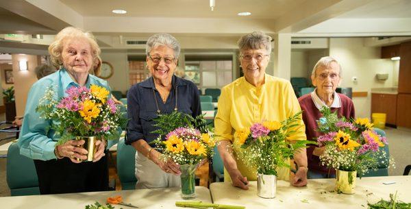 Residents enjoy a flower arranging class.