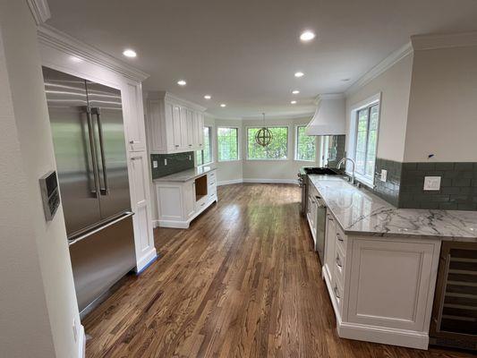 Custom built kitchen cabinets, hardwood floor, repairs to original hardwood, including sand and finish.