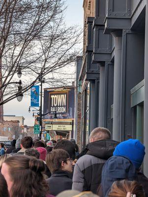 Lining up. Doors opened at 7 pm. The concert started an hour later.