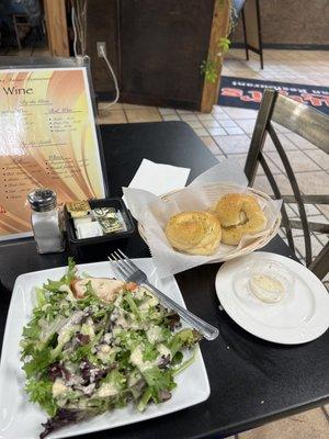 Salad with unique homemade Greek dressing, freshly baked garlic bread