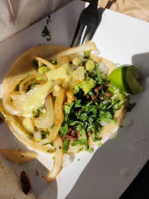 Carne asada taco with onions cilantro and guacamole