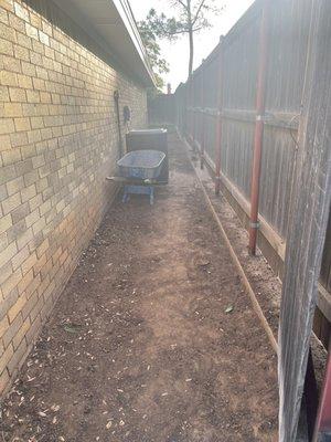 Before-Side of the house that was just dirt and made it difficult to get the lawnmower and trash can through, especially if it was muddy.