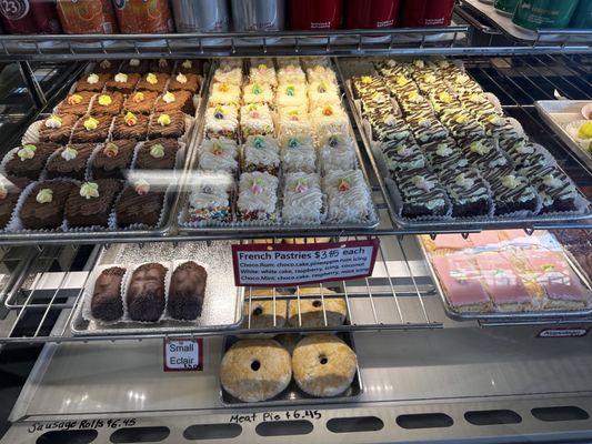 Delicious variety of rum cakes, eclairs, meat pies, and more