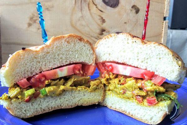 Curried Chicken(organic) Salad Roll. A pretzel flour bun embracing a curry organic salad, celery, chopped red peppers, raisins and  mayo.