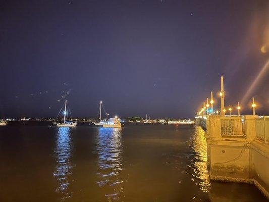 Boats sailing on the water next to the bridge of lions.