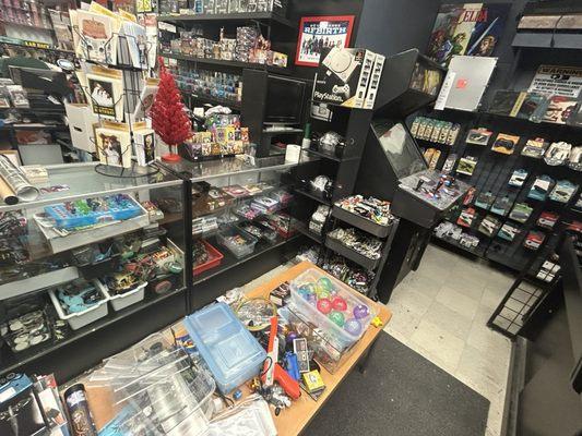 the area behind the cashiers with loose toys and retro controllers, games and some consoles. also some dvds behind me