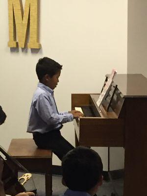 Student playing piano at one of our recitals.