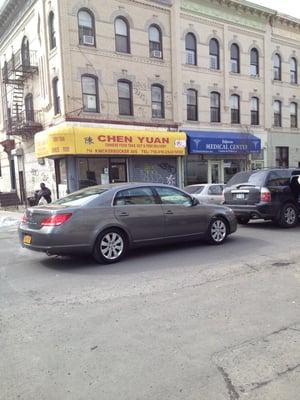 On the corner, with a sign the color of a New York taxicab.