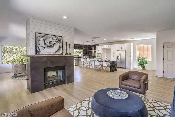 New Flooring, accent fireplace, white cabinetry with black finishes. Double island in kitchen