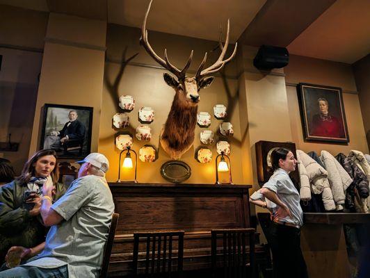 Inside. Cool decor. Old portraits and hunting trophies. Host/hostess stand to right.