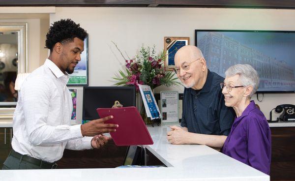 Oak Park Arms staff member shows activities list to seniors in the community