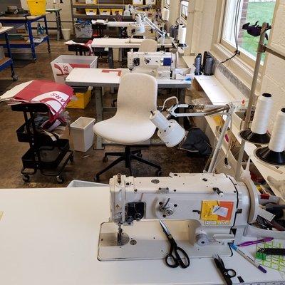 a row of industrial sewing machines to transform the materials into useful items