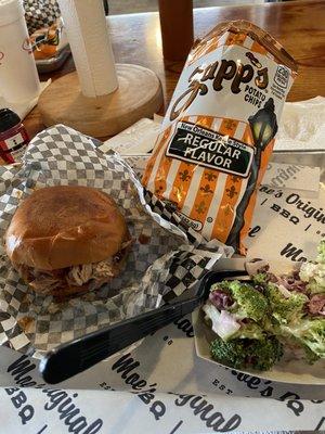 BBQ pork sandwich with chips and broccoli salad