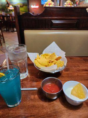 Chips and dips with blue Hawaiian special drink