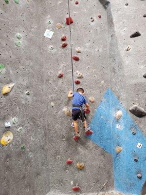 Indoor rock climbing for his first time at Vertical Hold.