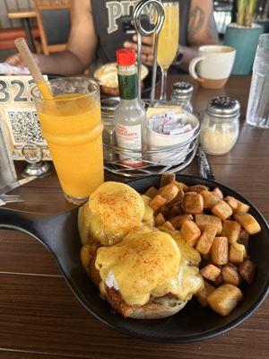 Spicy pork belly eggs Benedict with a side of potatoes and a mango smoothie