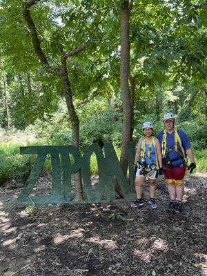 Us beside their sign and it's the gear in view