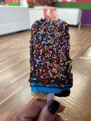 Cookie Monster frozen Ice cream pop dipped in chocolate with sprinkles.